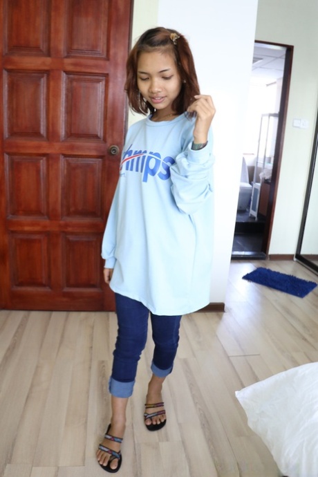 Pretty Asian girl Emelyn shows off her petite body while undressing for sex