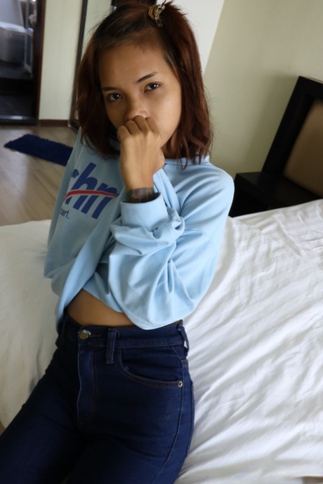 Pretty Asian girl Emelyn shows off her petite body while undressing for sex
