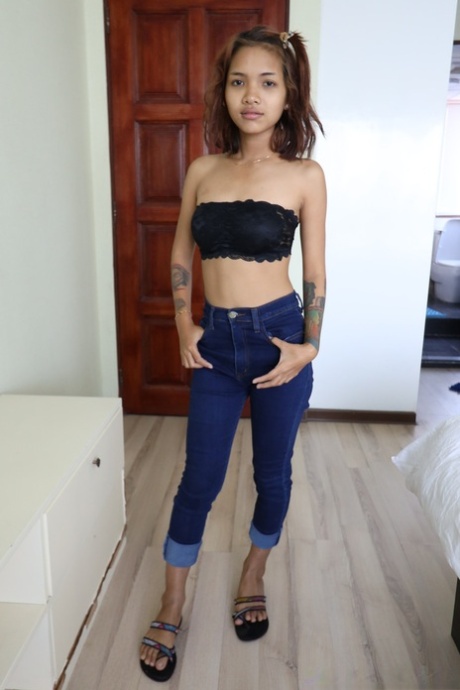 Pretty Asian girl Emelyn shows off her petite body while undressing for sex